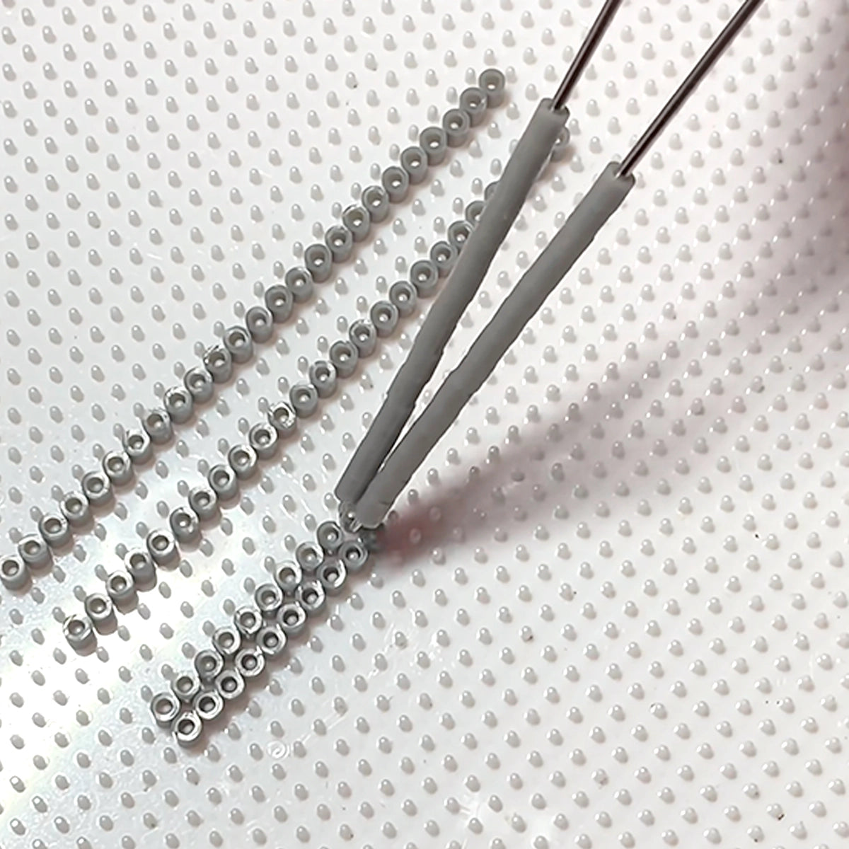 Close-up of the 2.6mm Pro Tool Kit for Tiny Fuse Beads in use, showing tools for precise bead handling and crafting.